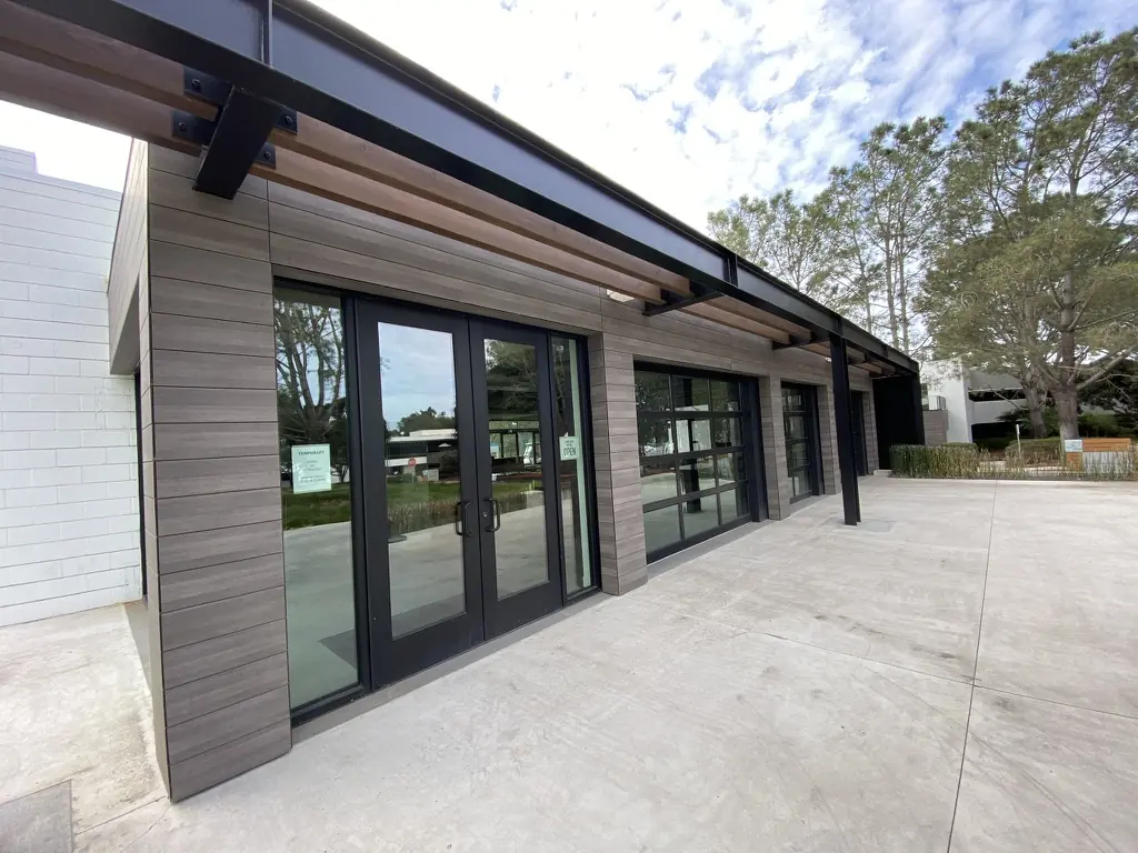 Glass entry doors under a steel canopy