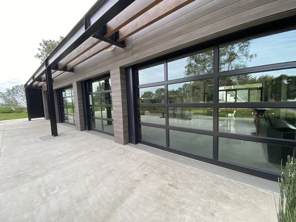 Glass roll-up doors on a commercial building with window film installed by Tint Solutions