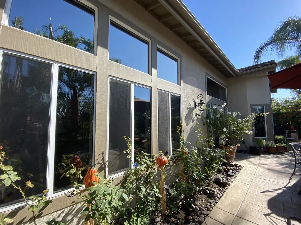 Tall window wall along a garden walkway