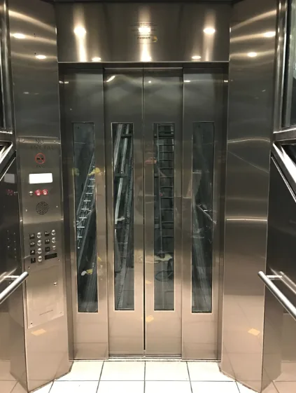 Elevator with glass panels in stainless doors