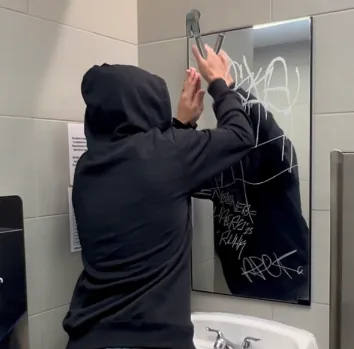 Restroom mirror being tagged by a vandal