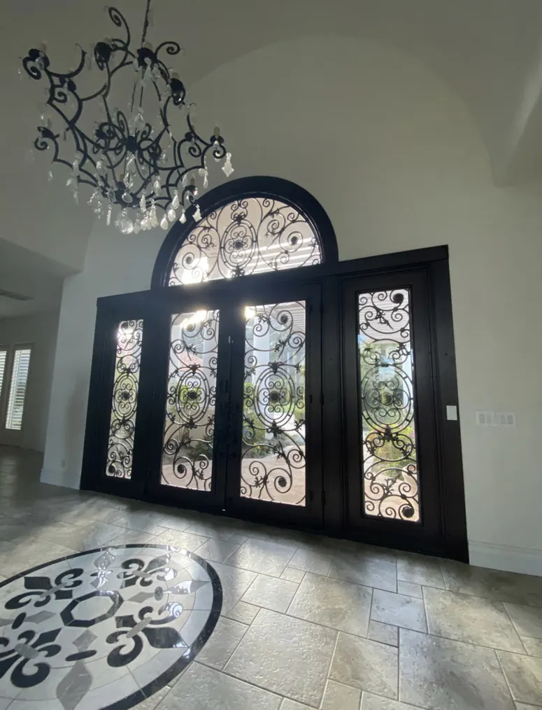Wrought-iron entry doors with an arched transom