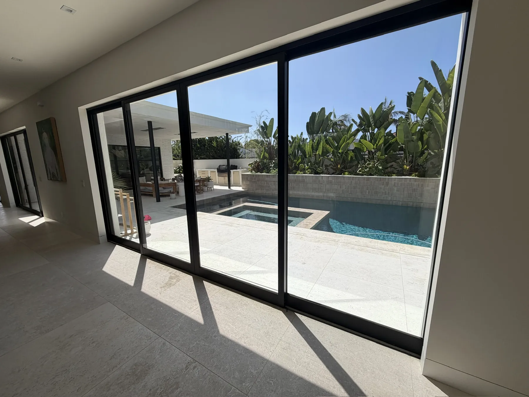 View through filmed sliding glass doors to a backyard pool