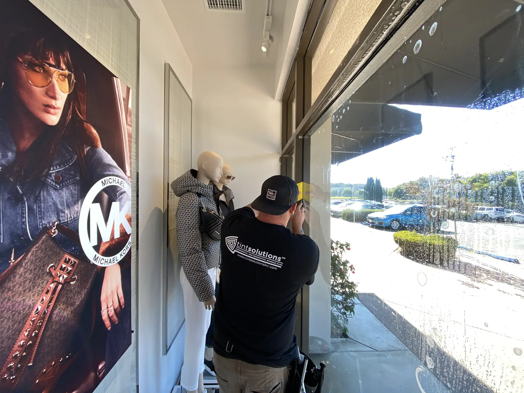 Installer applying security film on retail storefront glass