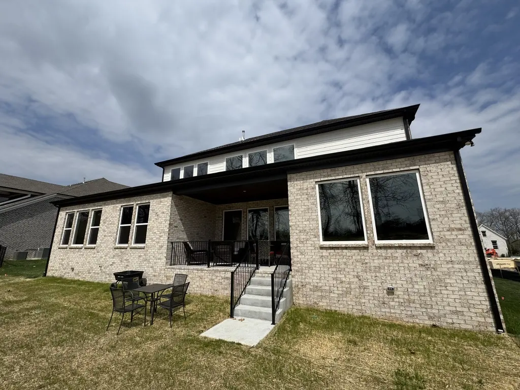 Back of a brick Middle Tennessee home with filmed windows on both floors