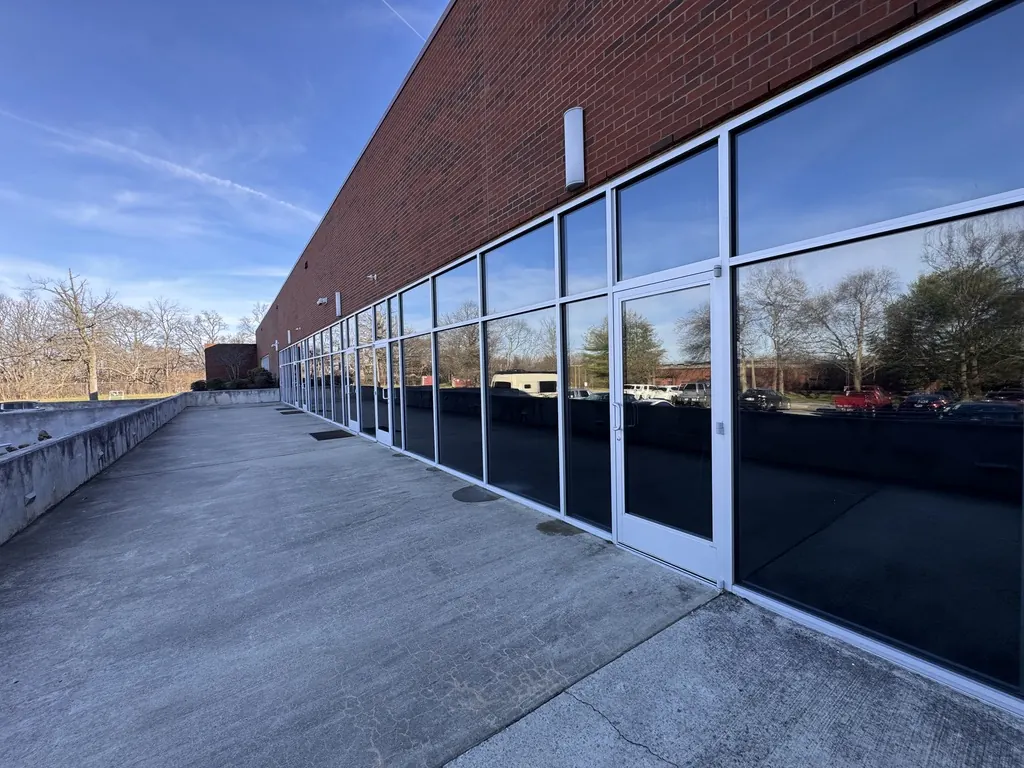 Brick commercial building with a long run of storefront glass and doors