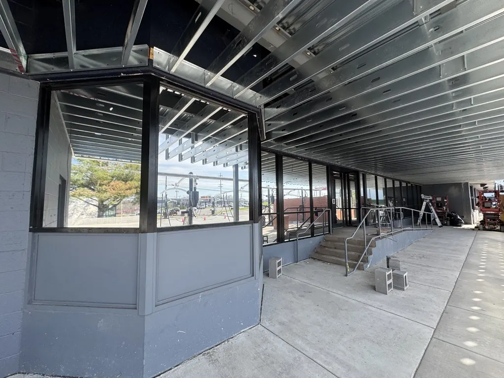 New-construction storefront glass under a steel canopy