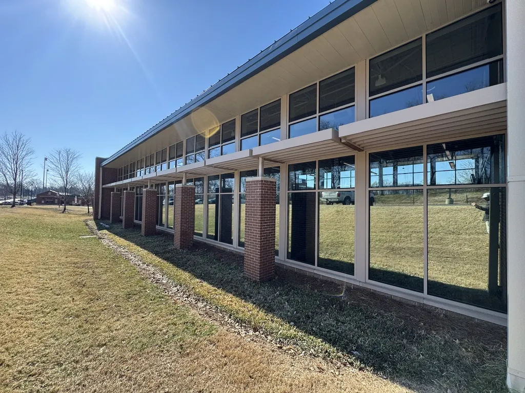 Two-story commercial window wall behind brick columns, Middle Tennessee project by Tint Solutions